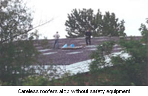 Careless roofers atop without safety equipment