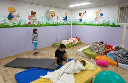 Israeli children wake up in the morning inside a bomb shelter at Kibbutz Reim, outside the central Gaza Strip November 18, 2012. Israel bombed Palestinian militant targets in the Gaza Strip from air and sea for a fifth straight day on Sunday, preparing for a possible ground invasion while also spelling out its conditions for a truce. Palestinian fire into Israel subsided during the night but resumed in the morning, with two rockets targeting Tel Aviv. REUTERS/Ronen Zvulun (ISRAEL - Tags: CIVIL UNREST POLITICS CONFLICT) CREDIT: REUTERS